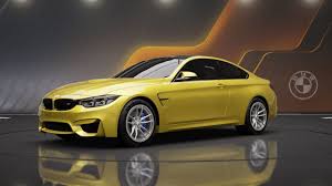 Yellow BMW M4 Coupe sports car on display with studio lighting