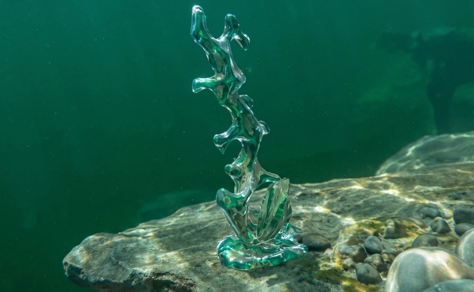 Glowing green crystalline structure on underwater rocky surface in Subnautica