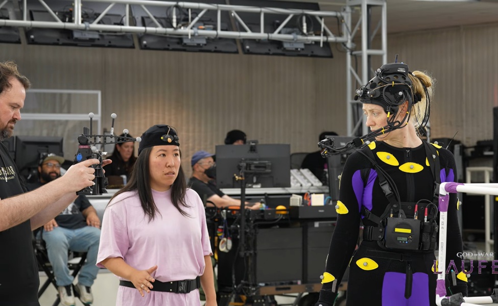 Developer discussing God of War Laufey character design with costumed performer at studio event