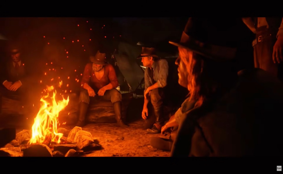 Group of cowboys sitting around a campfire at night in the desert